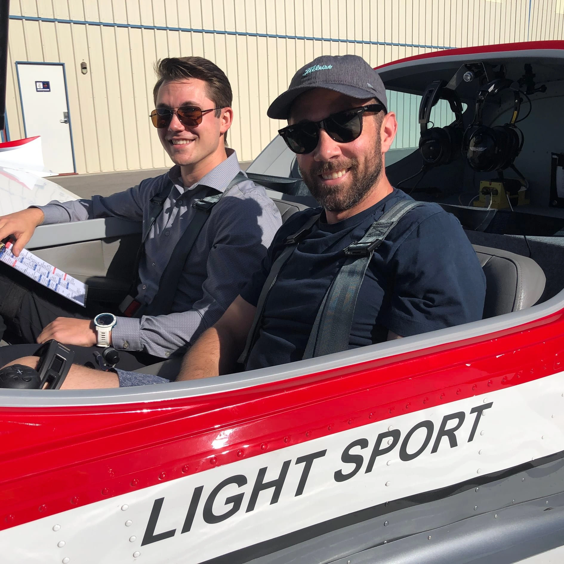 Student and instructor smiling inside an aircraft cockpit